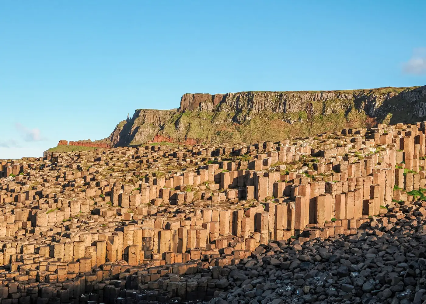 Zeshoekige basaltzuilen van de Giant's Causeway aan de kust bij zonsondergang