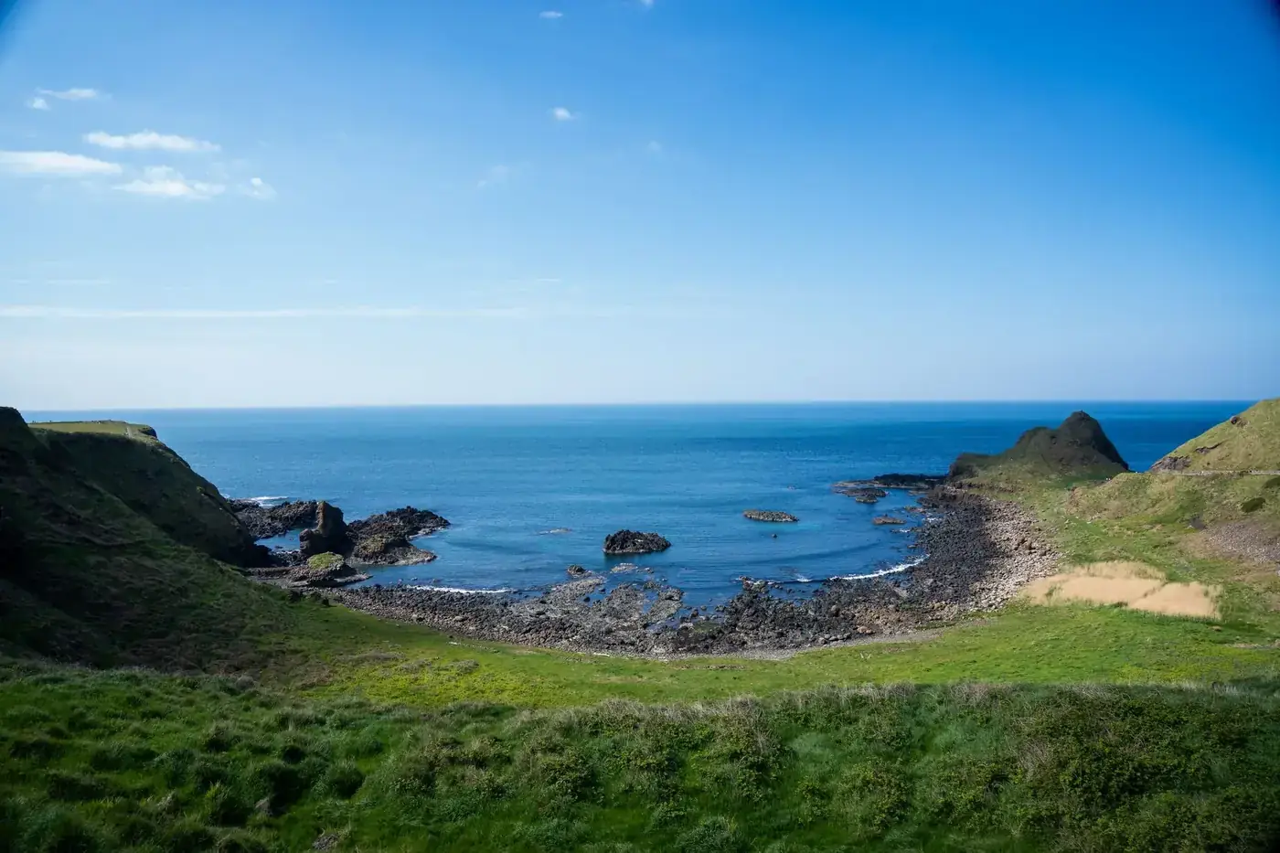 Breathtaking view of Giant's Causeway coastline under a clear blue sky.