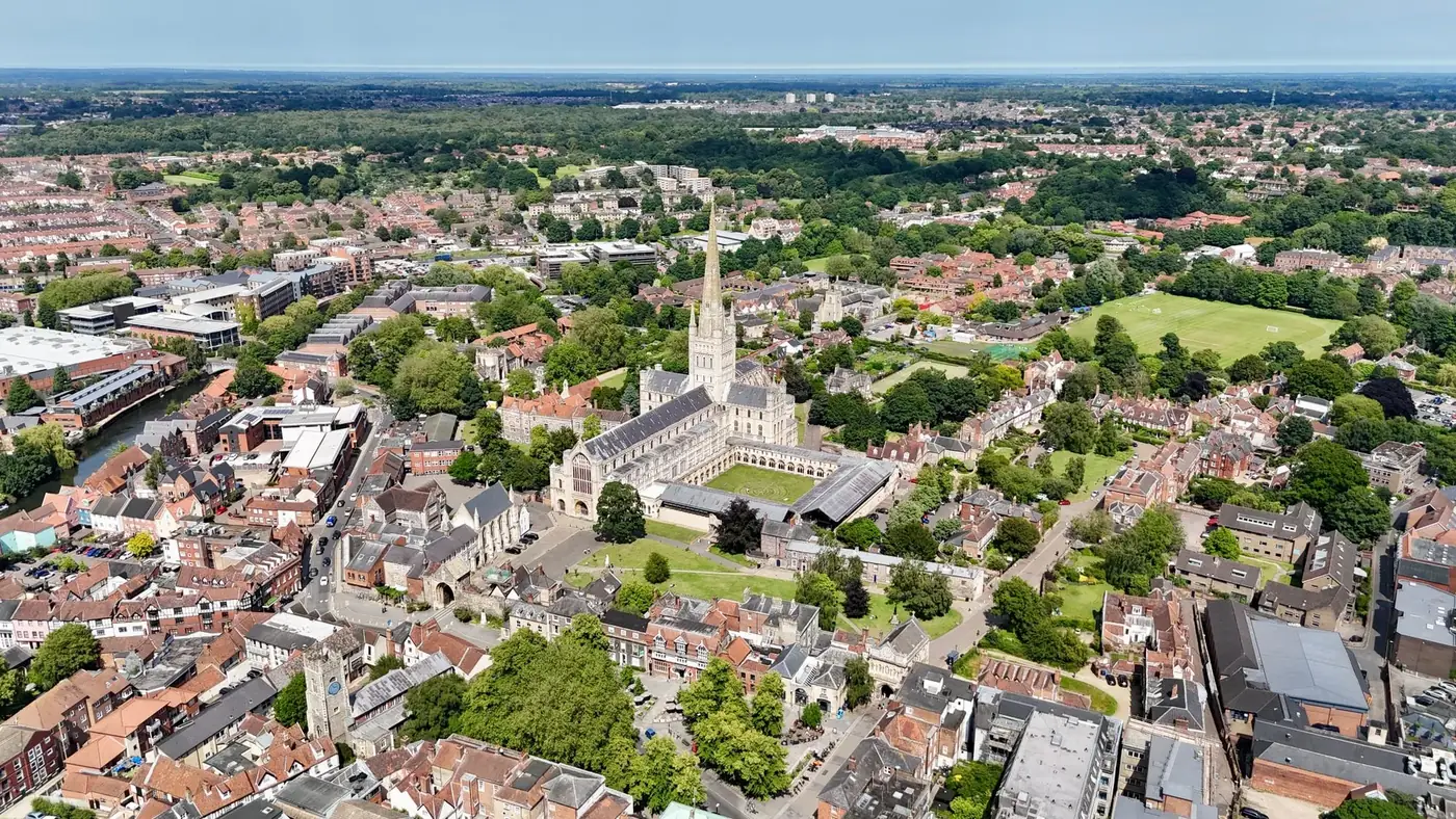 Aerial shot of Norwich Cathedral in Norfolk, showcasing urban and natural landscapes.