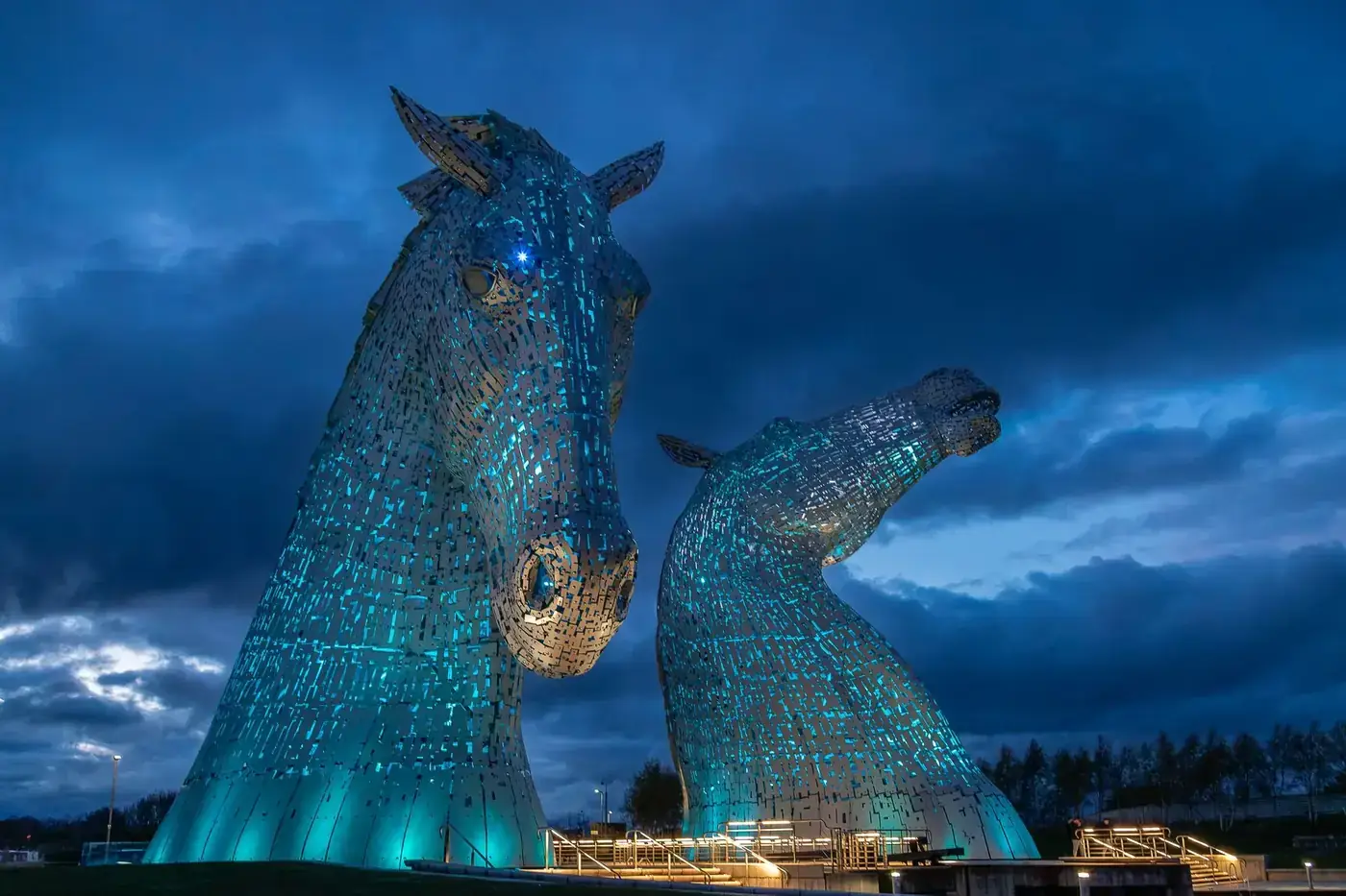 Majestic Kelpies illuminated at twilight in Grangemouth, Scotland, showcasing stunning architectural art.
