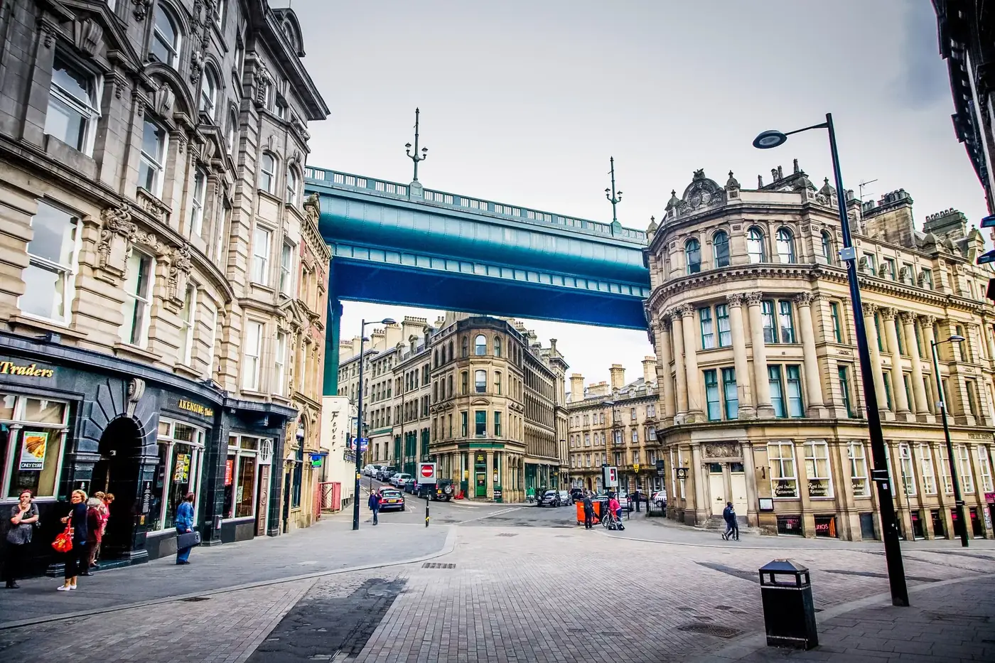 Street view of historic architecture and High Level Bridge in Newcastle, UK.
