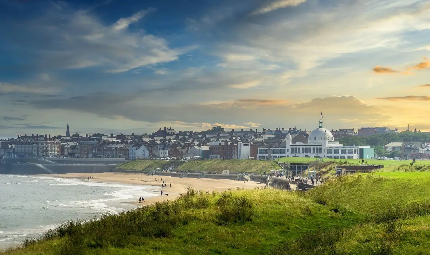 Captivating view of Whitley Bay, England with beach and cityscape at sunset.