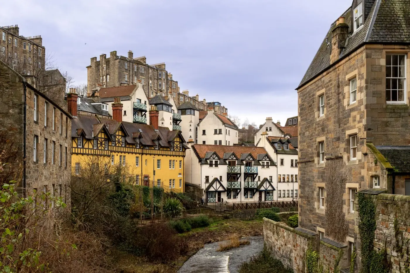 Explore the historic architecture of Dean Village, Edinburgh with its colorful buildings and serene riverbank.