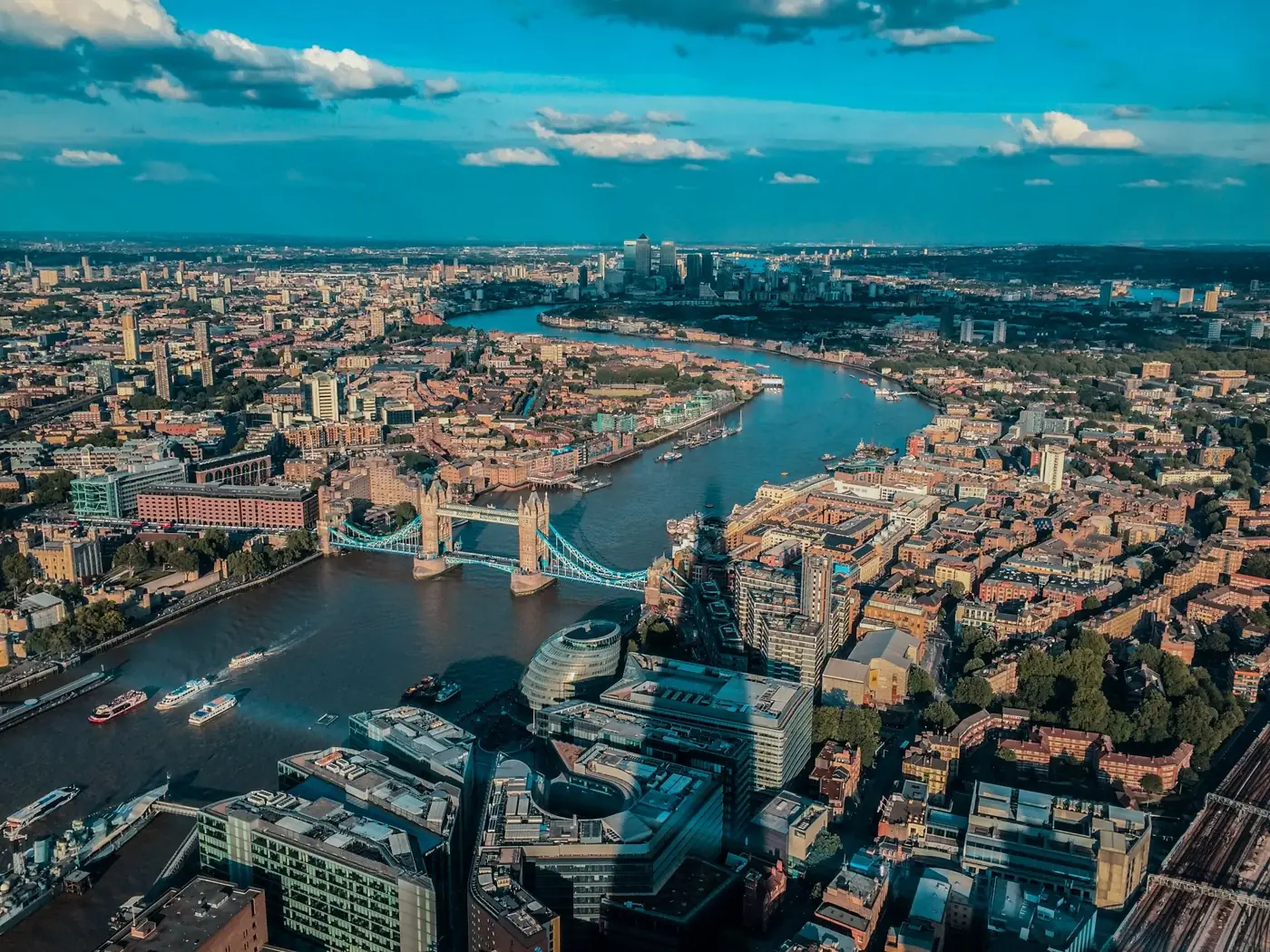 Aerial view of Tower Bridge spanning the Thames River in London with a clear sky.